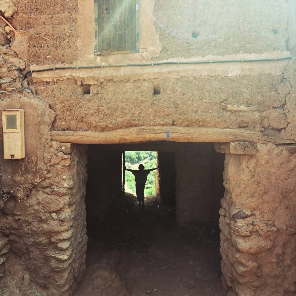 A silhouette of a person in a door way in an ancient Amazigh village